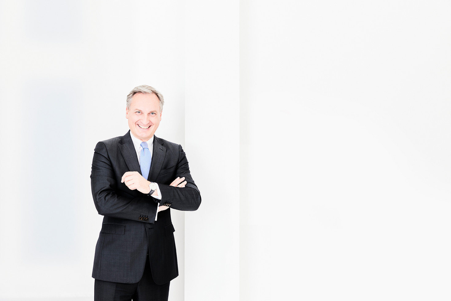 Markus Hilkenbach, Vorsitzender der Geschäftsführung der WSW Wuppertaler Stadtwerke GmbH lehnt sich an eine weiße Wand