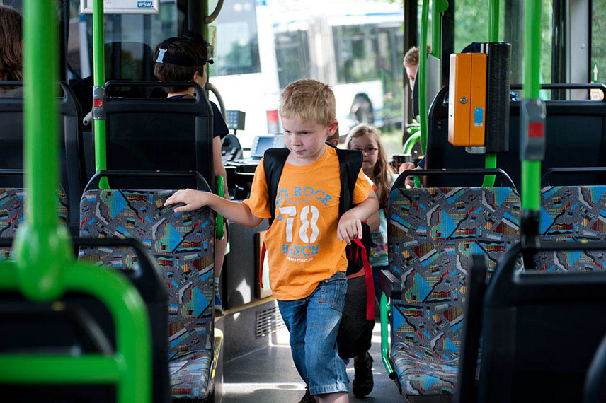 Ein Junge steigt in einen Bus und sucht einen Sitzplatz.