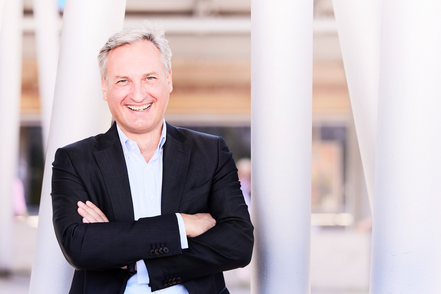 WSW Vorstandsvorsitzender Markus Hilkenbach guckt mit verschränkten Armen lachend in die Kamera