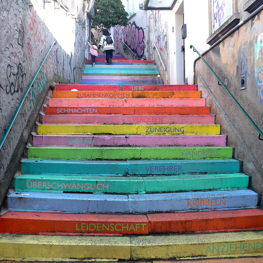 Foto einer bunt bemalten Treppe mit Wörtern auf jeder Stufe
